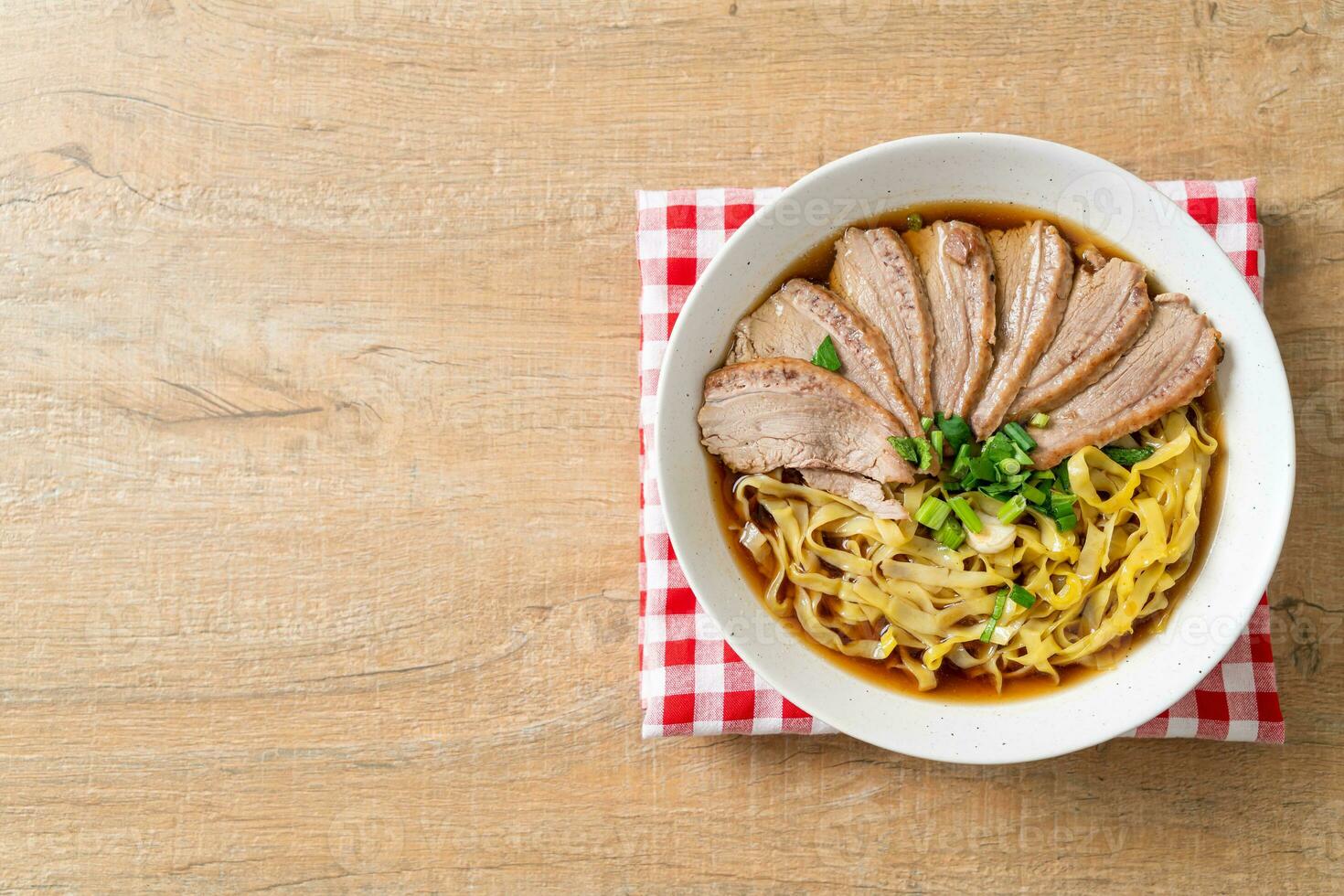 nouilles aux œufs avec ragoût de canard dans une soupe brune photo