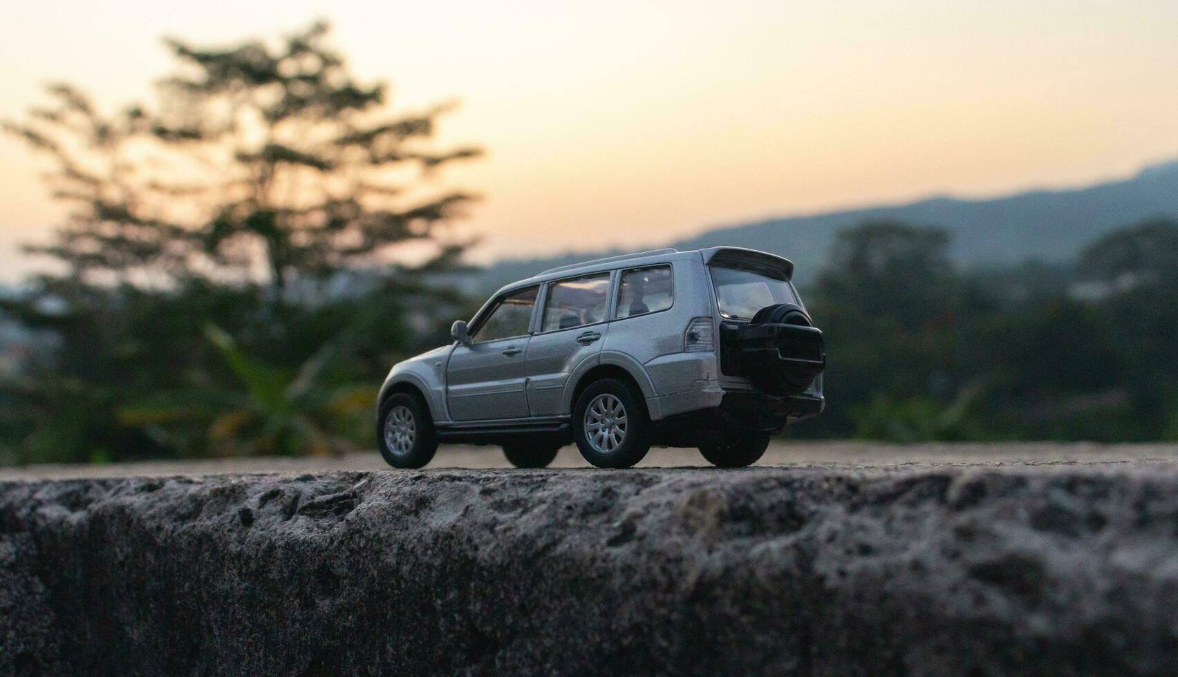 concept pour Voyage et aventure. une jouet voiture avec une Montagne vue dans le de bonne heure Matin. photo