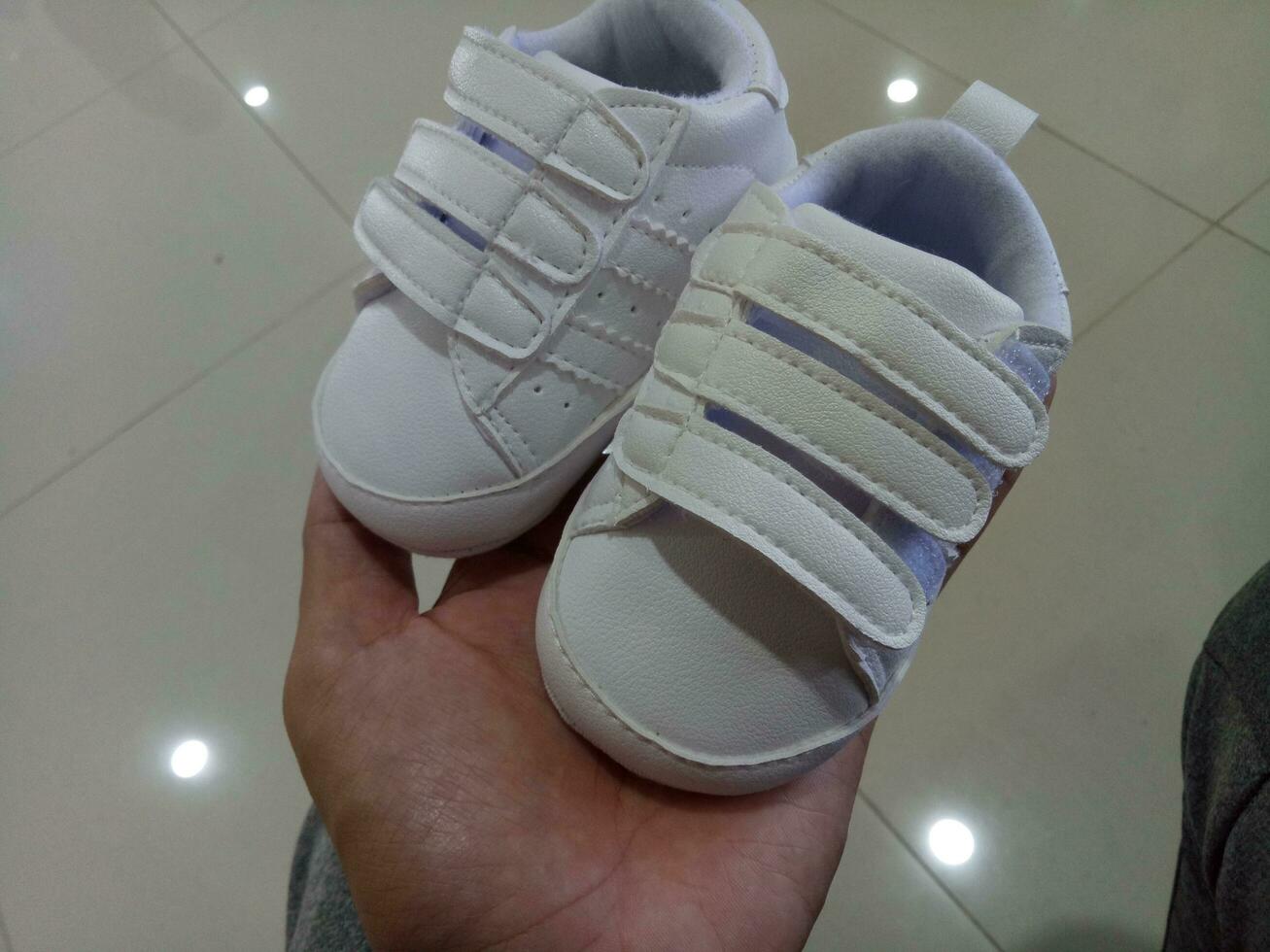 photo de une mignonne peu blanc bébé chaussure avec tripler adhésif