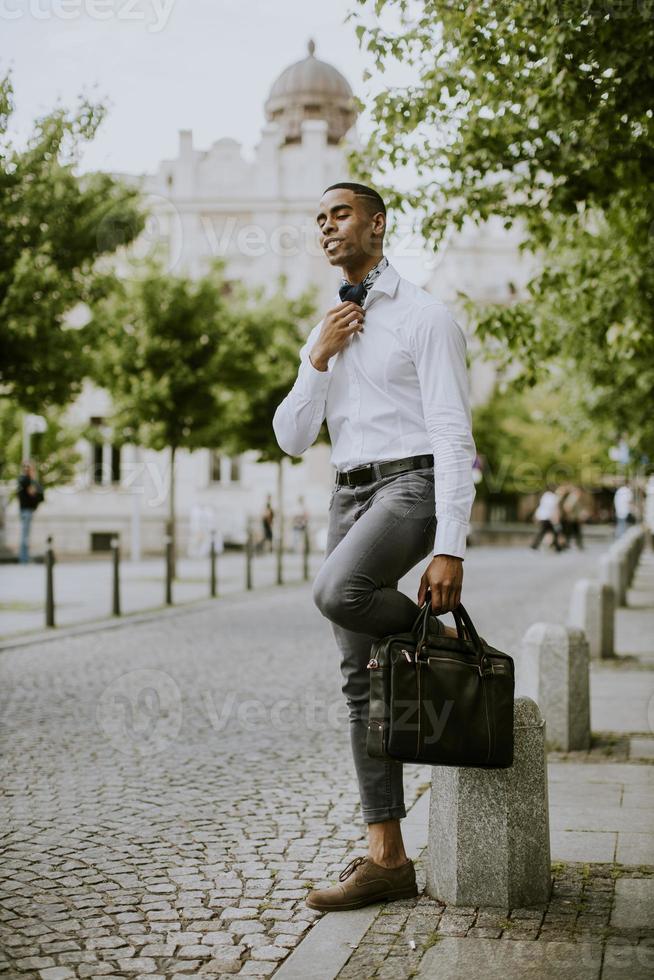 jeune homme d'affaires afro-américain en attente d'un taxi dans une rue photo