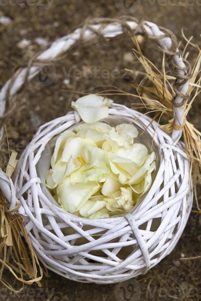 panier en bois avec des pétales de roses blanches photo