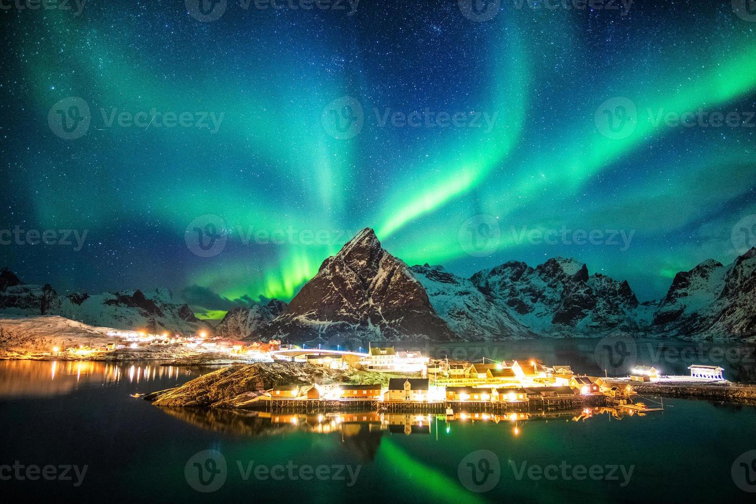 Aurore boréale sur les montagnes dans le village de pêcheurs photo