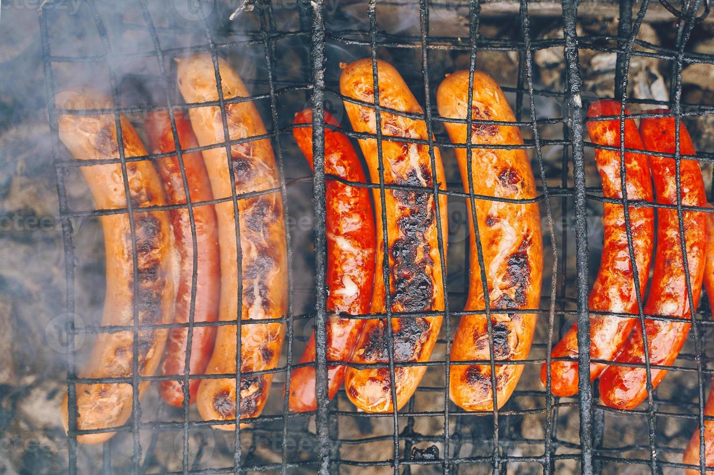 barbecue avec saucisses ardentes hot-dog sur le gril photo