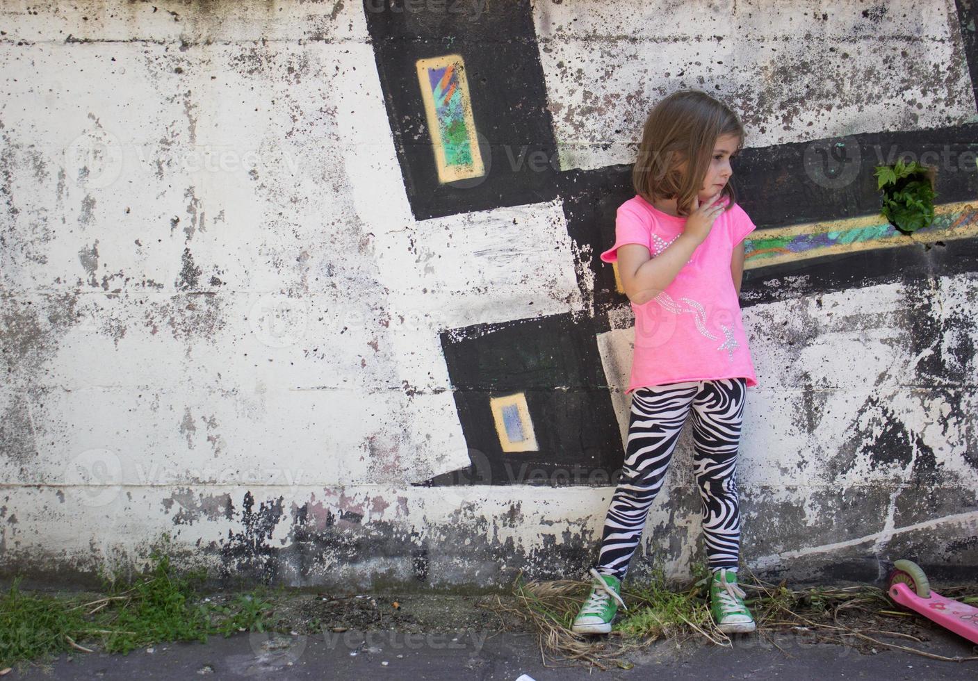 petite fille devant un mur de graffitis photo
