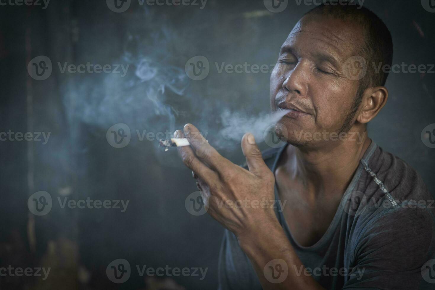 homme fumant une cigarette. propagation de la fumée de cigarette. concept de sevrage tabagique photo