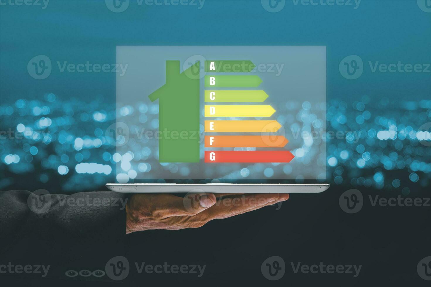 la personne main en utilisant tablette ordinateur avec maison icône énergie Efficacité échelle image sur Bureau bureau, concept de écologique et bio énergique maison. énergie classe. photo