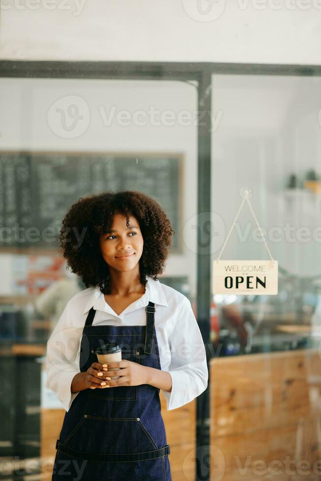 Commencez réussi petit affaires propriétaire pme africain femme supporter avec tablette dans café restaurant. femme barista café propriétaire. photo