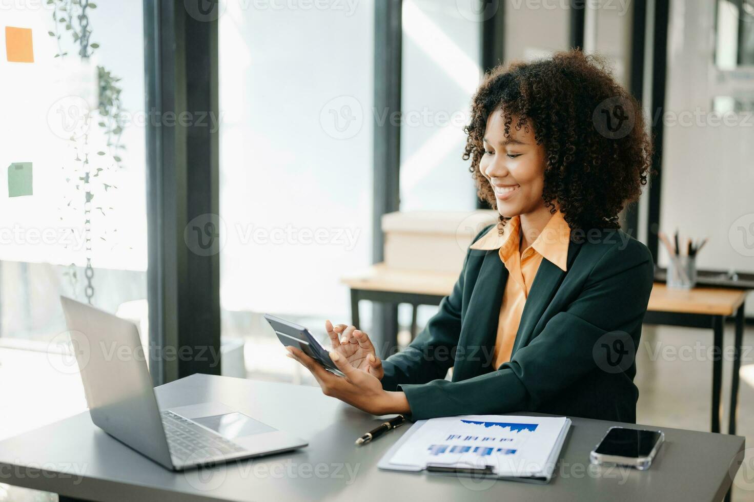 africain femmes compte pièces de monnaie sur calculatrice prise de le porcin banque. main en portant stylo travail sur calculatrice à calculer sur bureau à propos Coût à Accueil bureau. photo