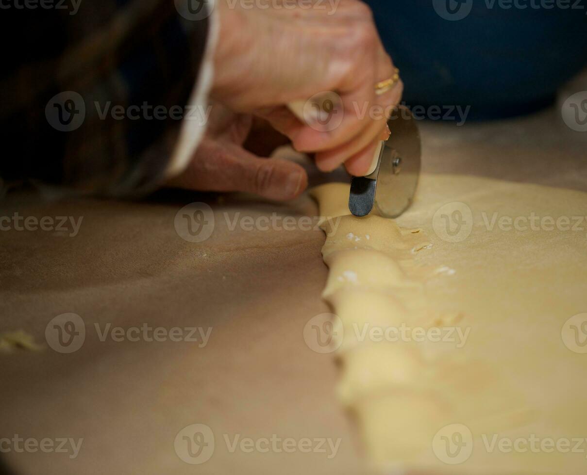 vieux femme est en train de préparer fait maison Ravioli avec fromage photo