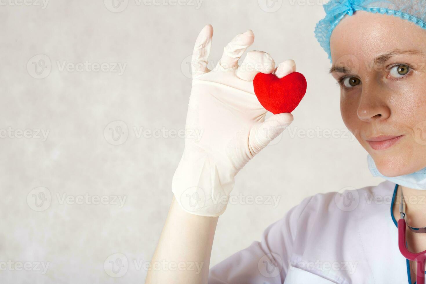 une rouge peluche cœur dans le main de une médecin photo