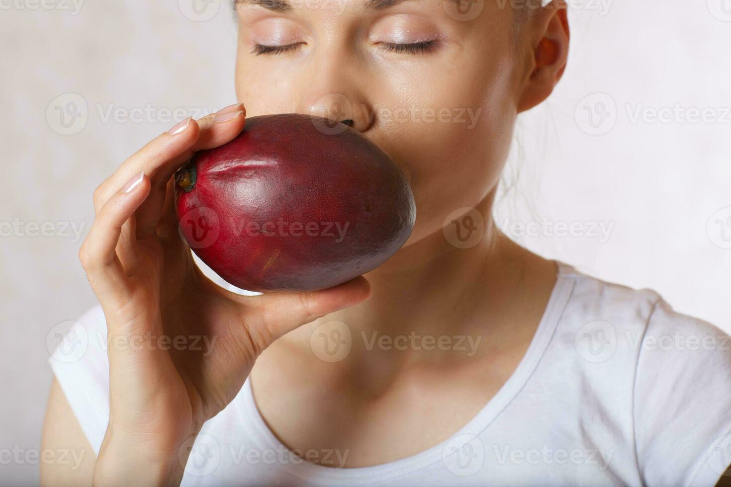 Jeune Dame est en gardant mangue proche à sa affronter. fermer photo