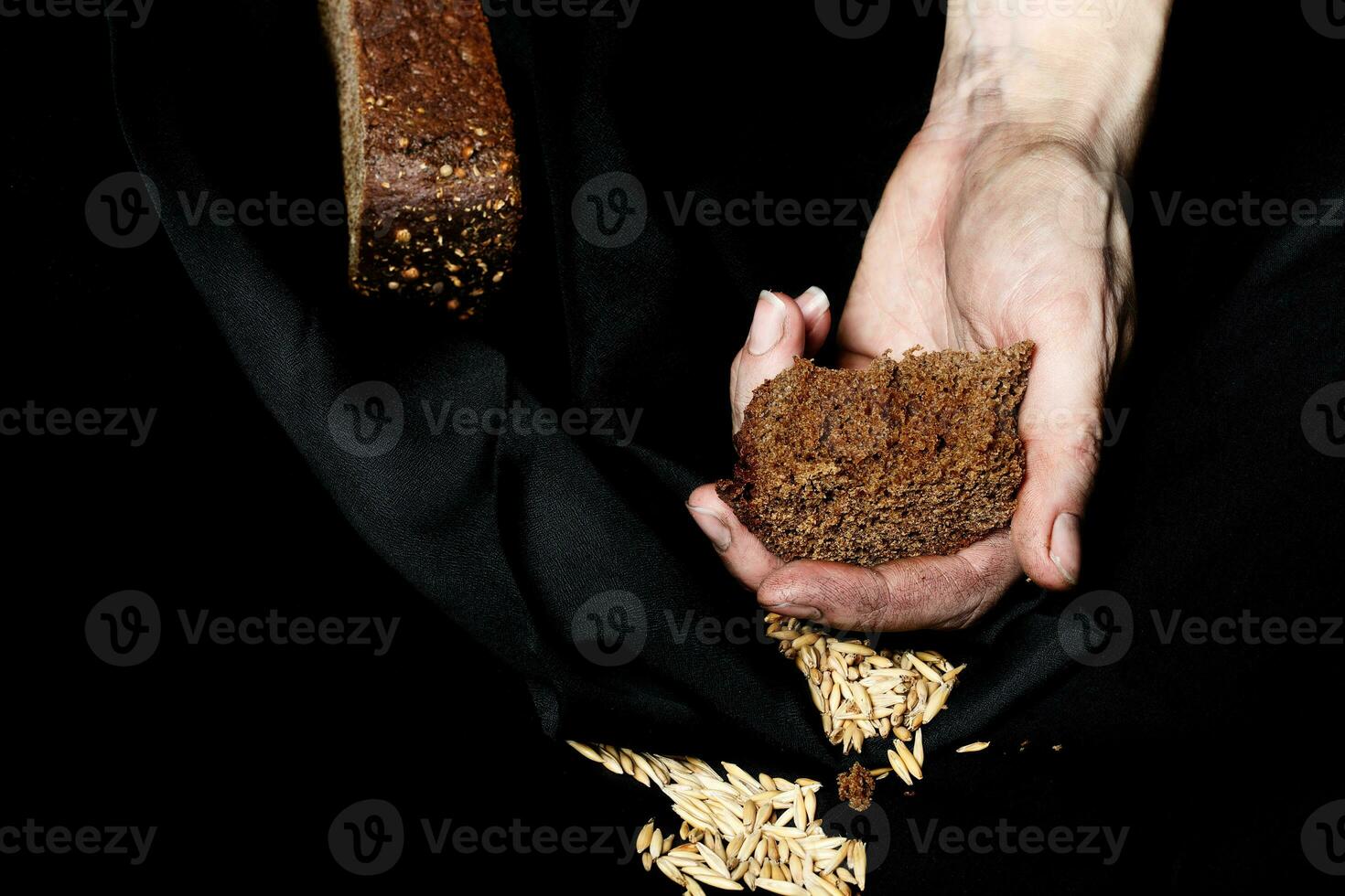 paume de une paysan femme avec seigle pain sur une noir tissu. photo