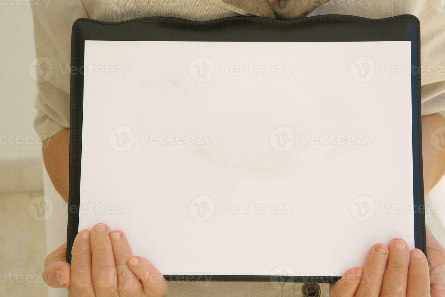 une blanc feuille de une papier dans le mains de Sénior femme photo