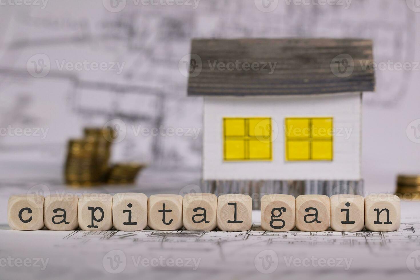mots Capitale Gain composé de en bois lettre. petit papier maison dans le Contexte. photo