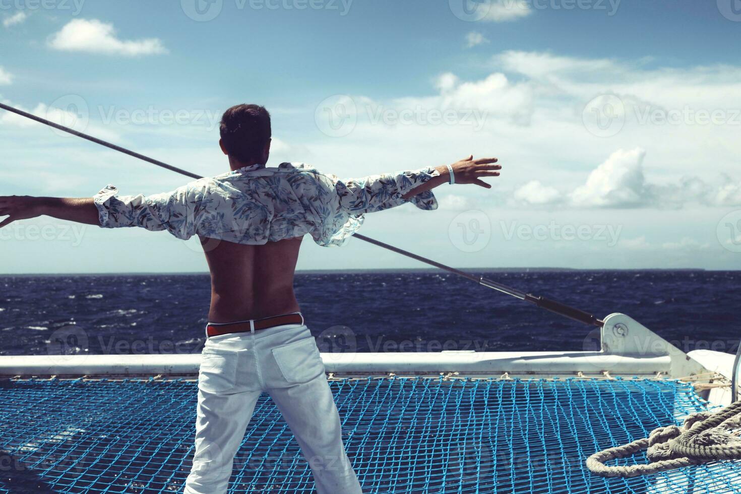 jeune homme naviguant sur son bateau en pleine mer photo