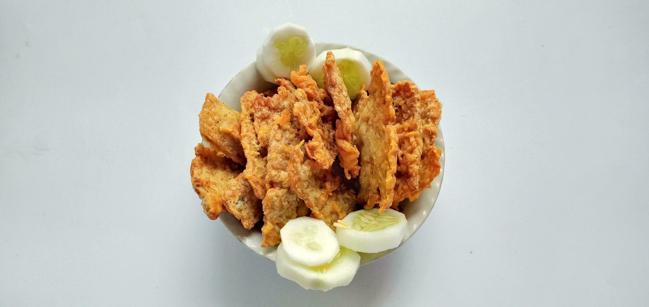 frit tempeh, kéripik tempérer ou tempérer frites sur une blanc Contexte. infonésien rue aliments. frit tempérer est un de pop-up rue nourriture dans Indonésie. indonésien rue aliments. photo