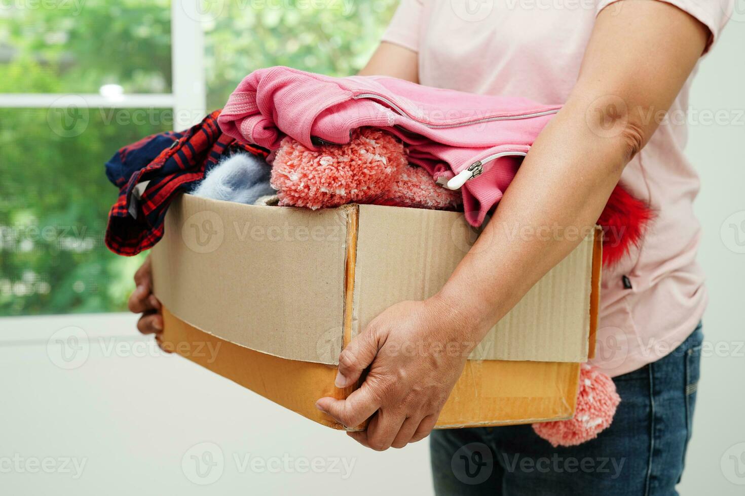 dons de vêtements dans une boîte en carton pour les bénévoles. photo