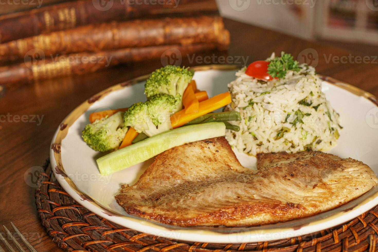 magnifique assiette de grillé poisson avec riz. dans le Contexte vieux livres photo