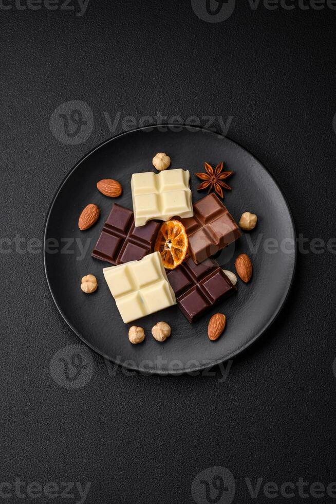 une mélanger de nombreuses les types de délicieux sucré Chocolat cassé dans cubes sur une noir assiette photo