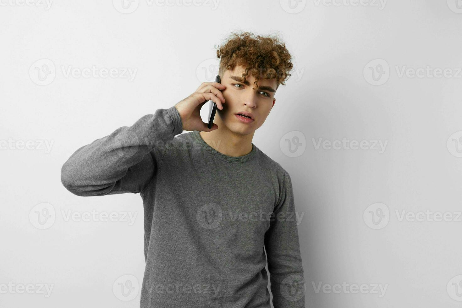 Beau Jeune homme avec une téléphone dans main la communication isolé Contexte photo