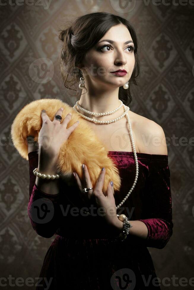 rétro femme portrait. magnifique fille avec rouge fourrure dans le style de le Années 20 ou 30s. vieux à la mode doigt vague maquillage et coiffure. photo