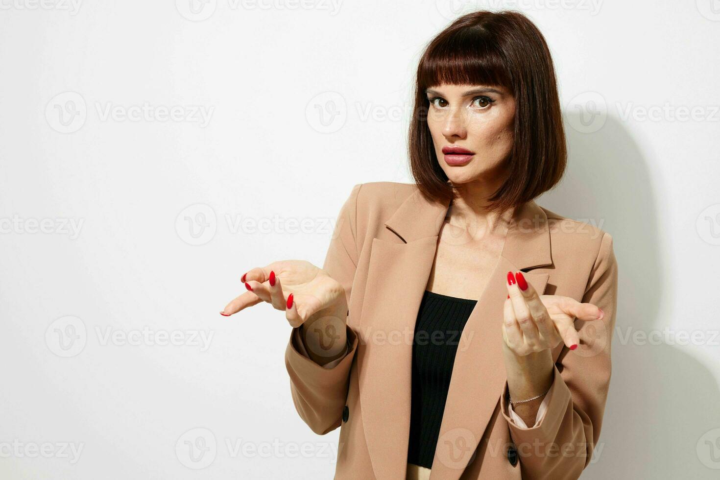 portrait de une femme court aux cheveux costume faire des gestes avec mains lumière Contexte photo