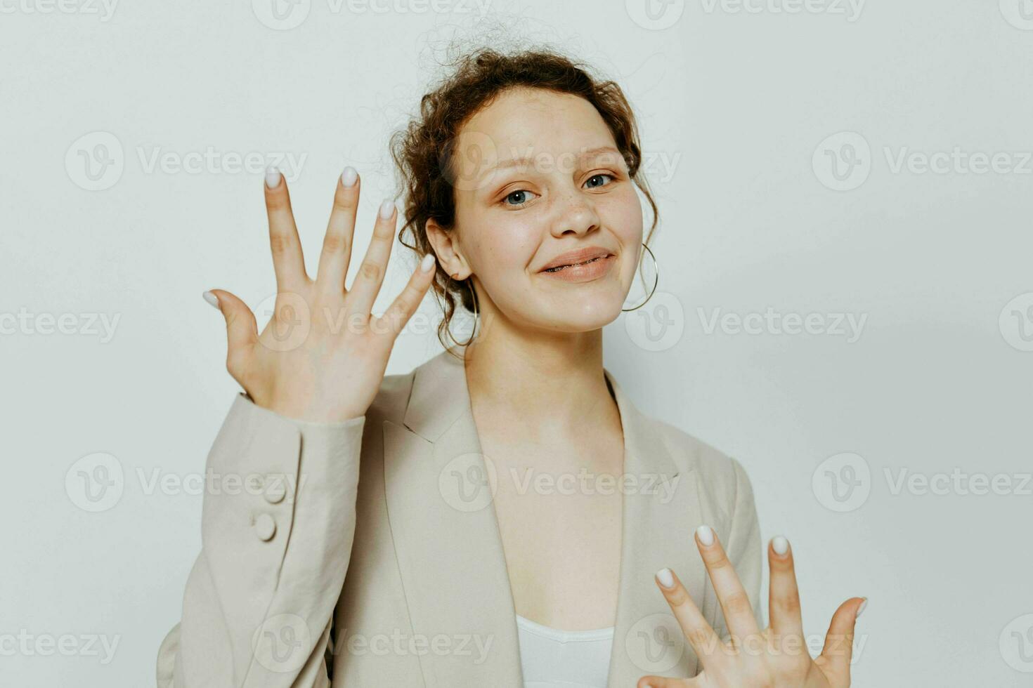 portrait de une Jeune femme dans une costume gestes avec le sien mains isolé arrière-plans inchangé photo