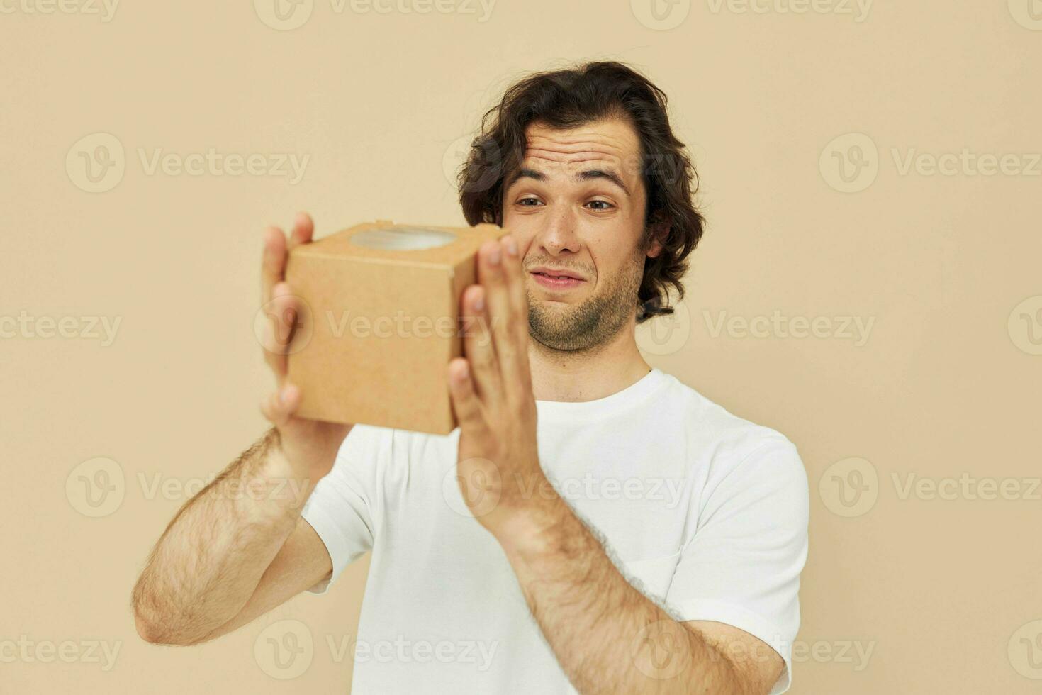 Beau homme en portant une papier carton petit boîte dans le sien mains photo