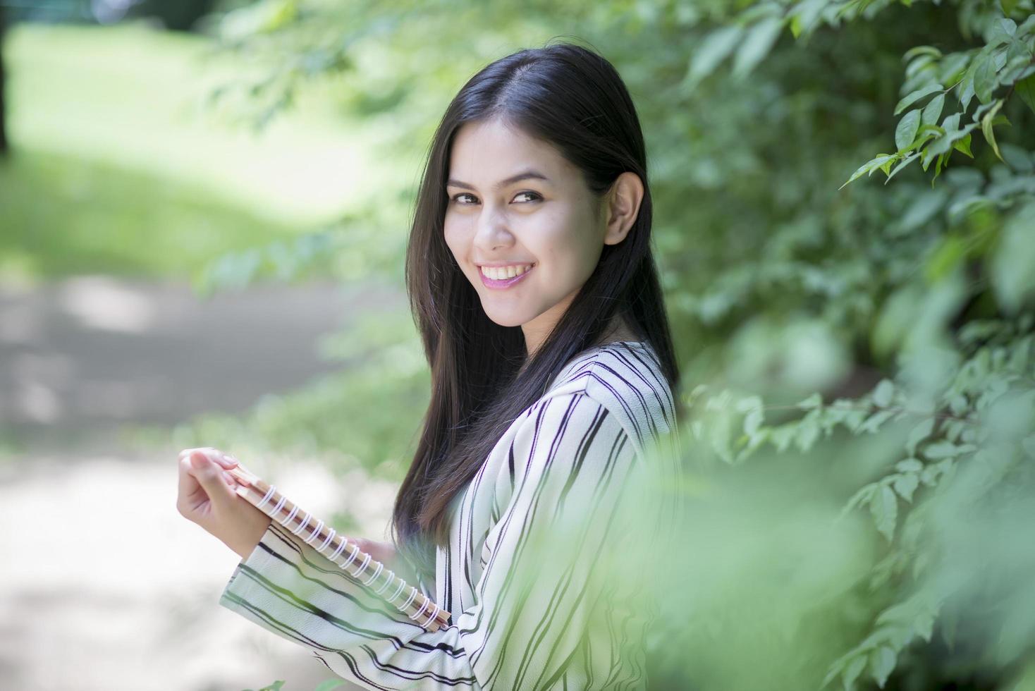 jolie femme lisant un livre dans le parc photo