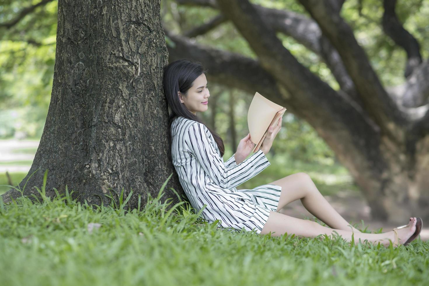 jolie femme lisant un livre dans le parc photo