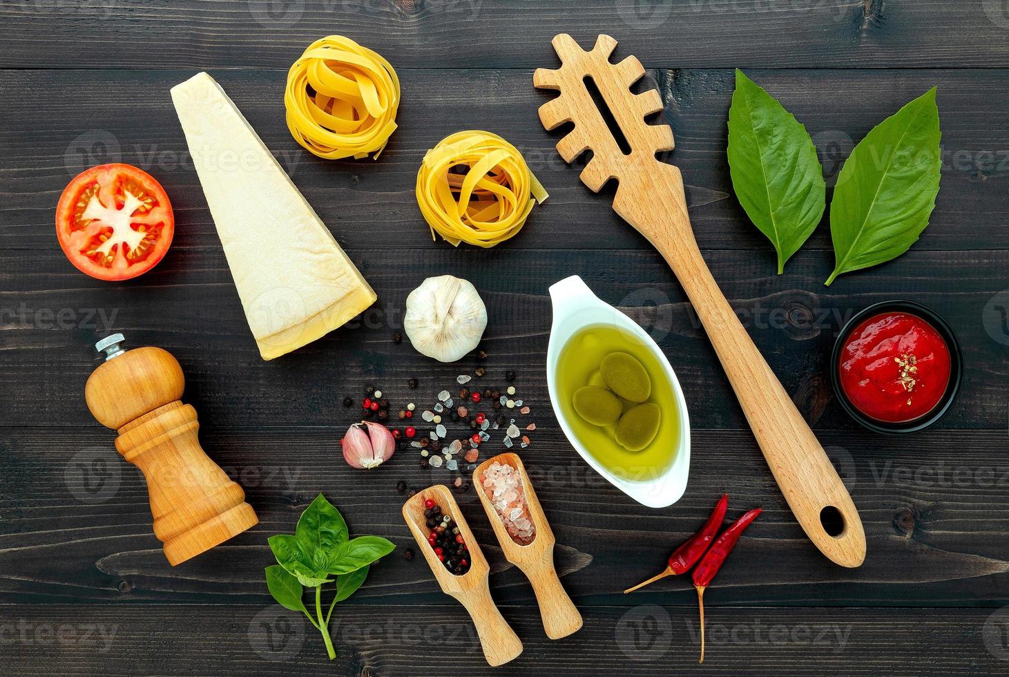 Pâtes italiennes jaunes sur fond de bois noir avec des ingrédients cuisine italienne et concept de menu photo