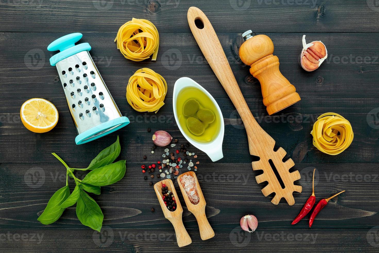 Pâtes italiennes jaunes sur fond de bois noir avec des ingrédients cuisine italienne et concept de menu photo