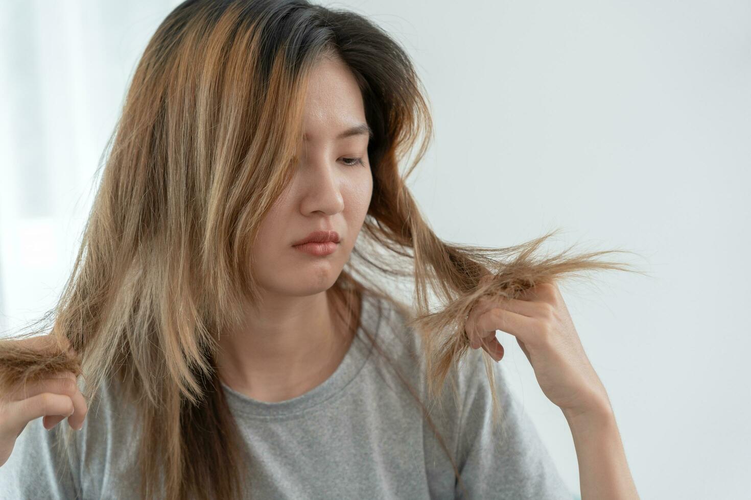 asiatique femme très triste et dérangé à la recherche à endommagé cheveux, cheveux perte, cheveux éclaircie problème, vitamine carence, calvitie, post-partum, biotine, zinc, menstruel ou endocrine troubles, hormonale déséquilibre photo