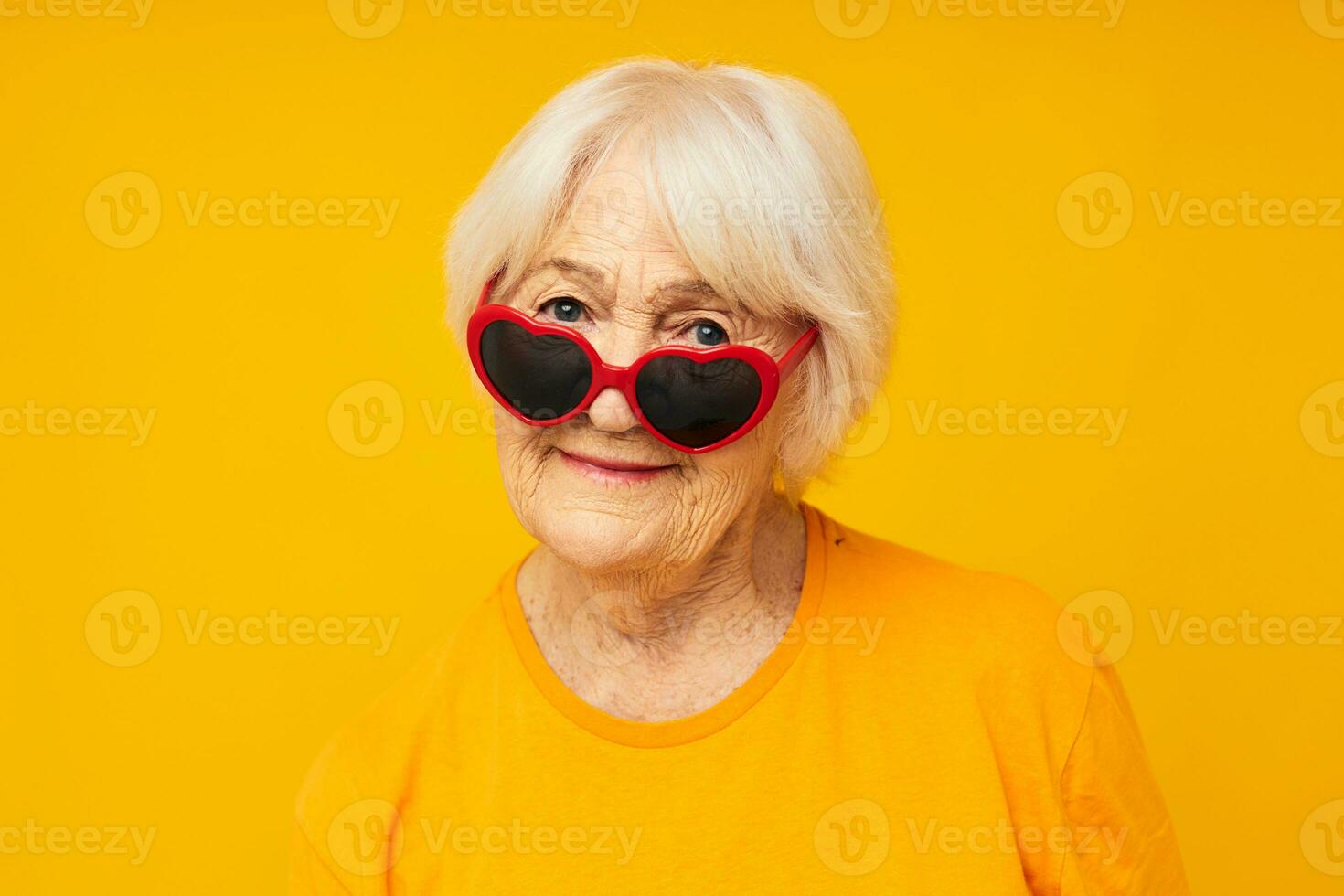 photo de retraité vieux Dame dans foncé des lunettes dans le forme de une cœur  Jaune Contexte 25016404 Photo de stock chez Vecteezy