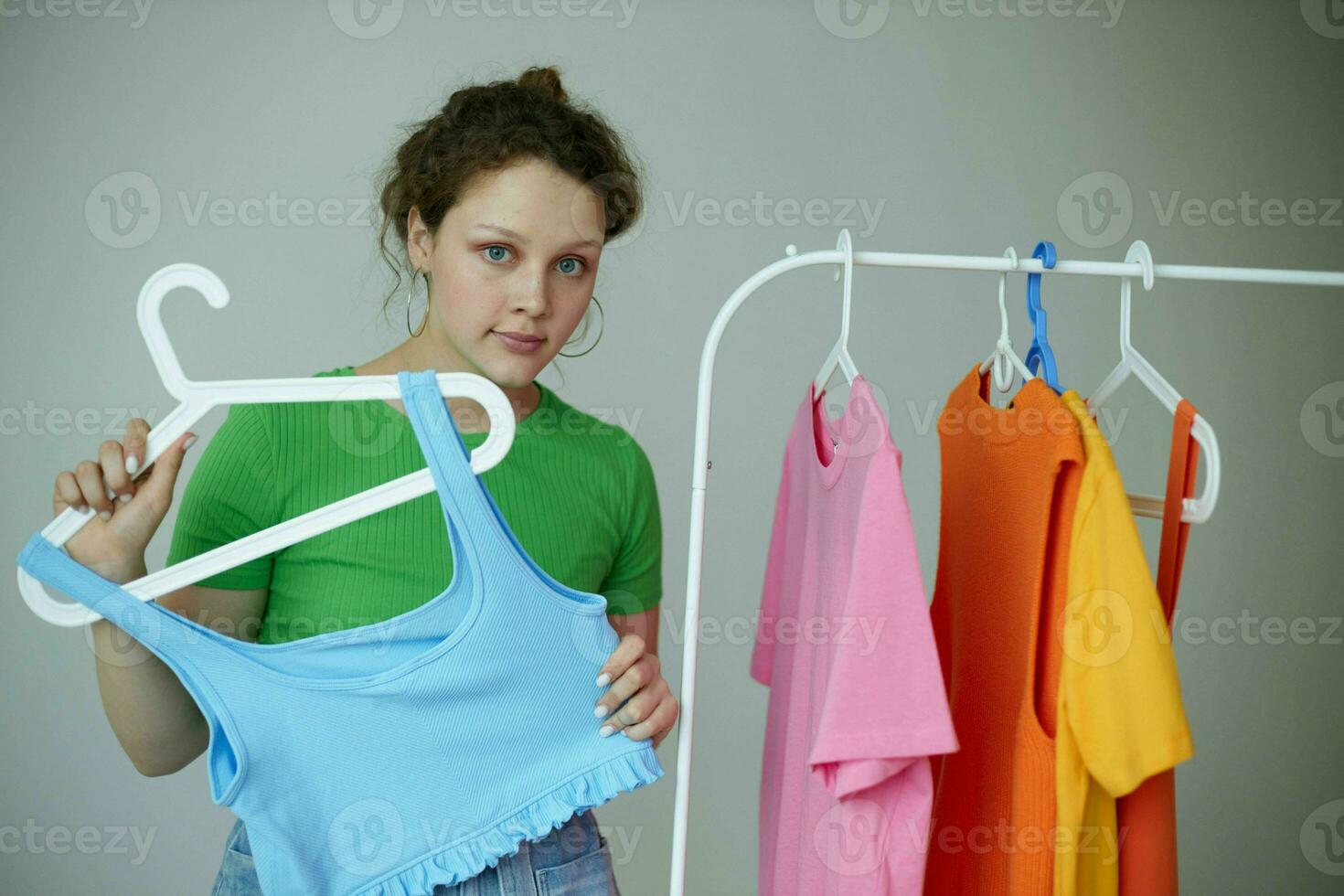 portrait de une Jeune femme en essayant sur vêtements garde-robe jeunesse style lumière Contexte inchangé photo