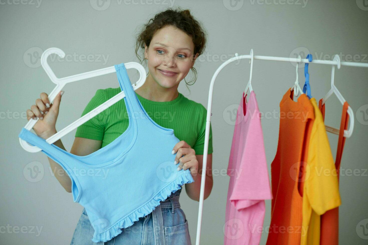 portrait de une Jeune femme repassage vêtements sur une cintre garde-robe tondu vue inchangé photo