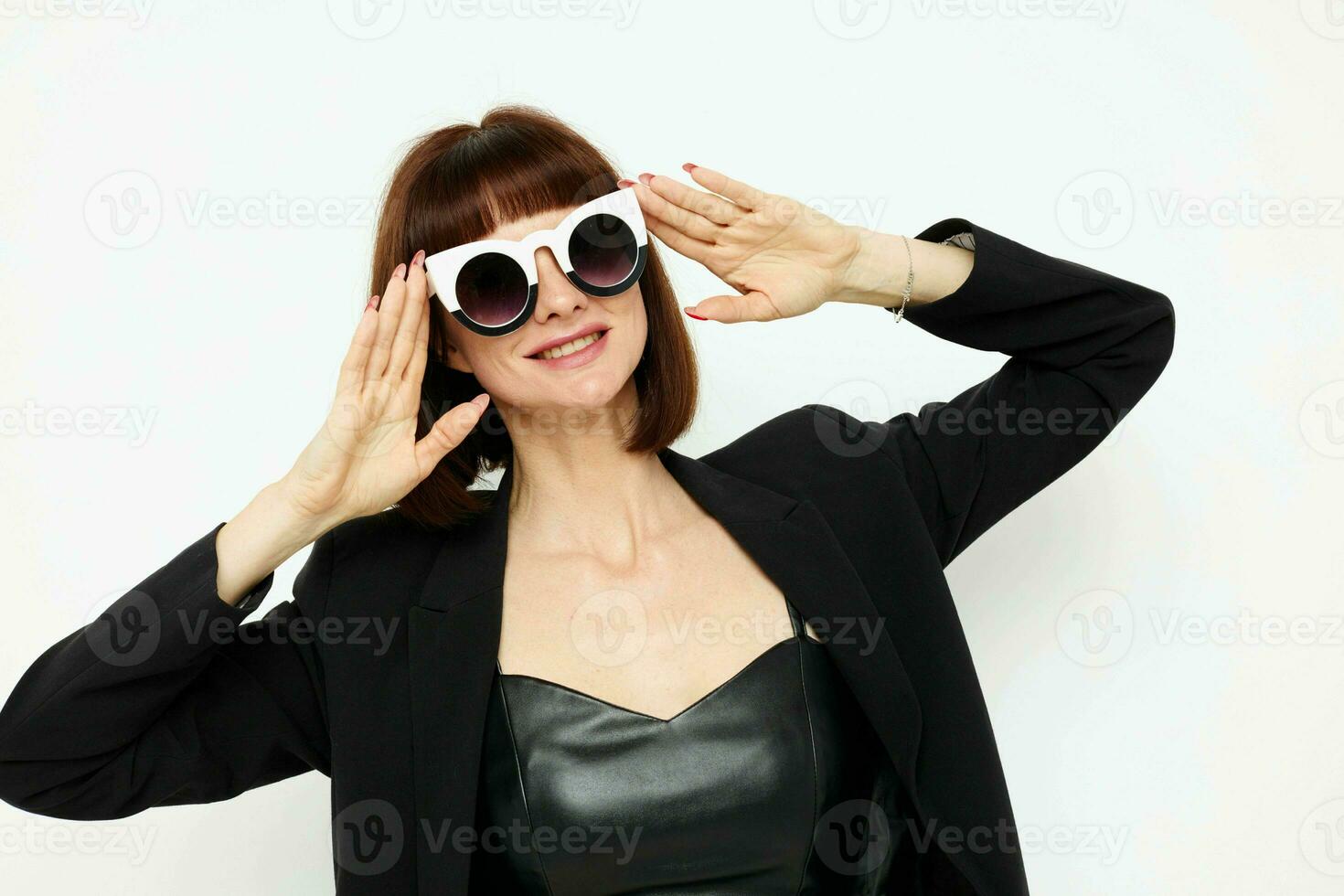 magnifique femme dans une noir veste rouge clou polonais élégant des lunettes de soleil isolé Contexte photo