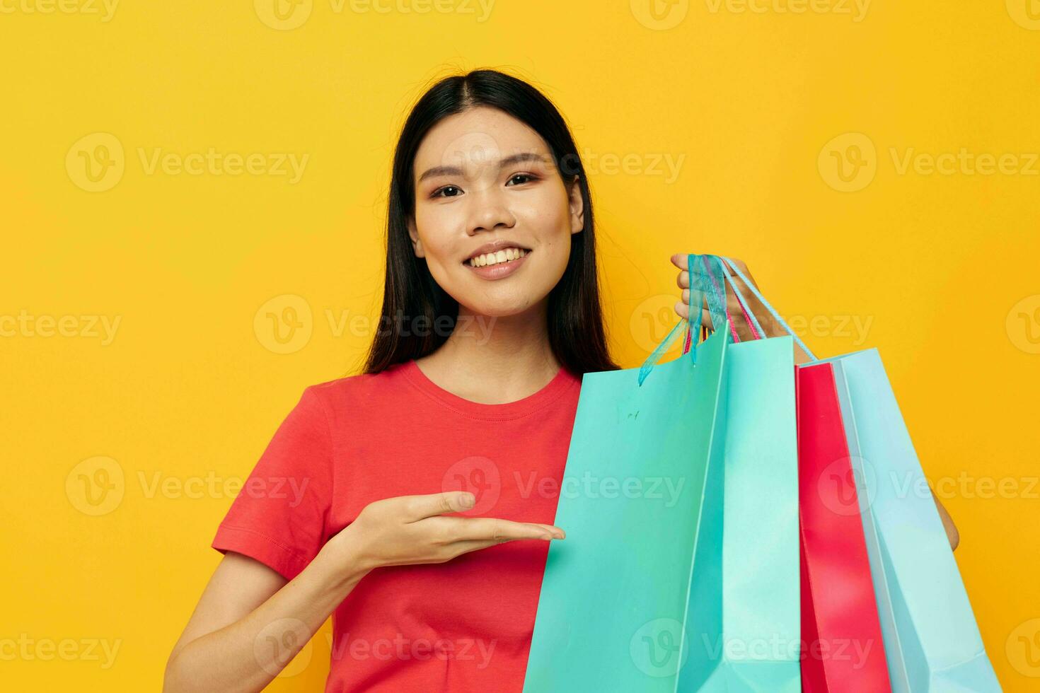 portrait asiatique magnifique Jeune femme avec multicolore achats Sacs Jaune Contexte inchangé photo