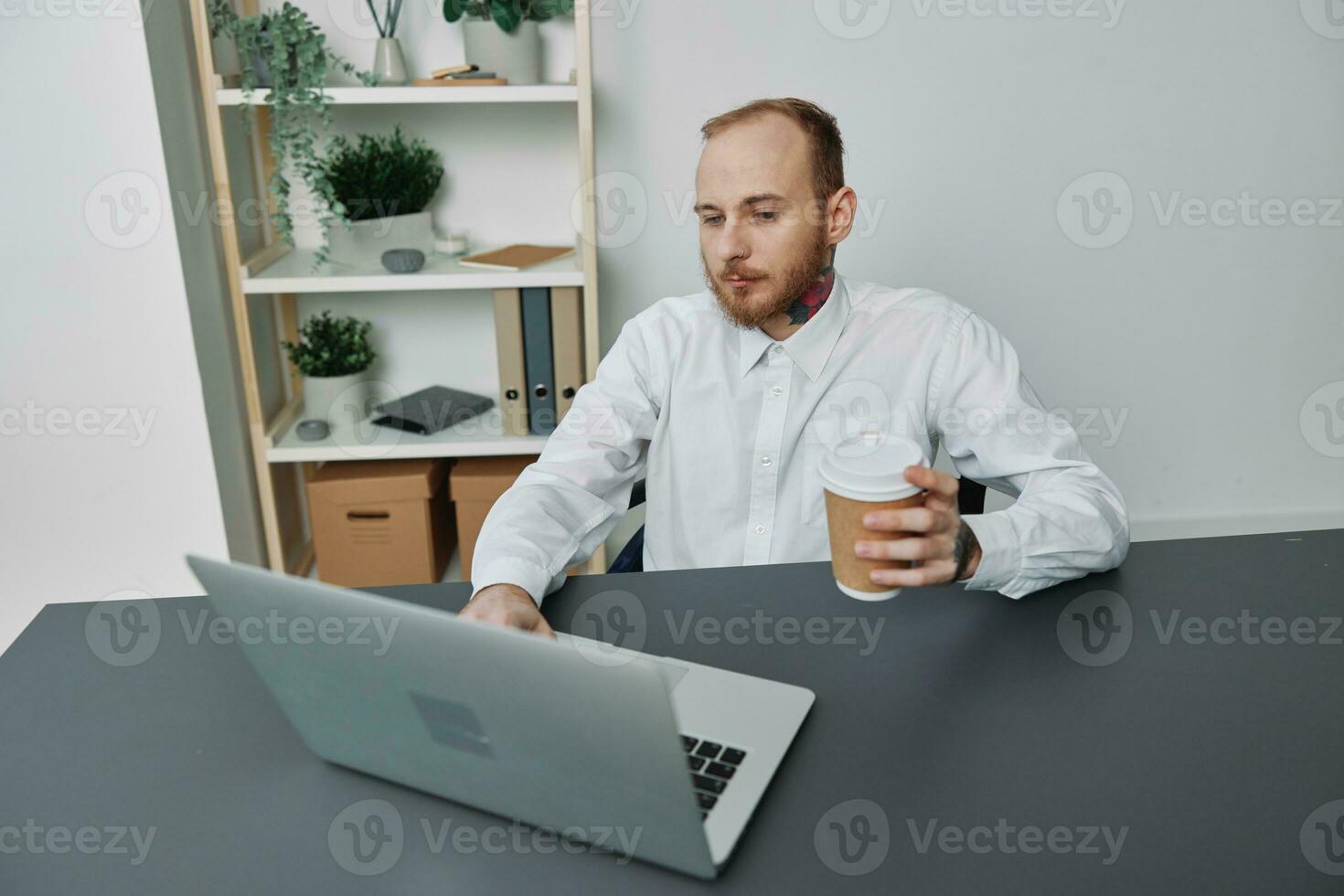 une homme dans une fauteuil roulant une homme d'affaire avec tatouages dans le Bureau travaux à une portable avec café, l'intégration dans société, le concept de travail une la personne avec handicapées, liberté de social cadre photo