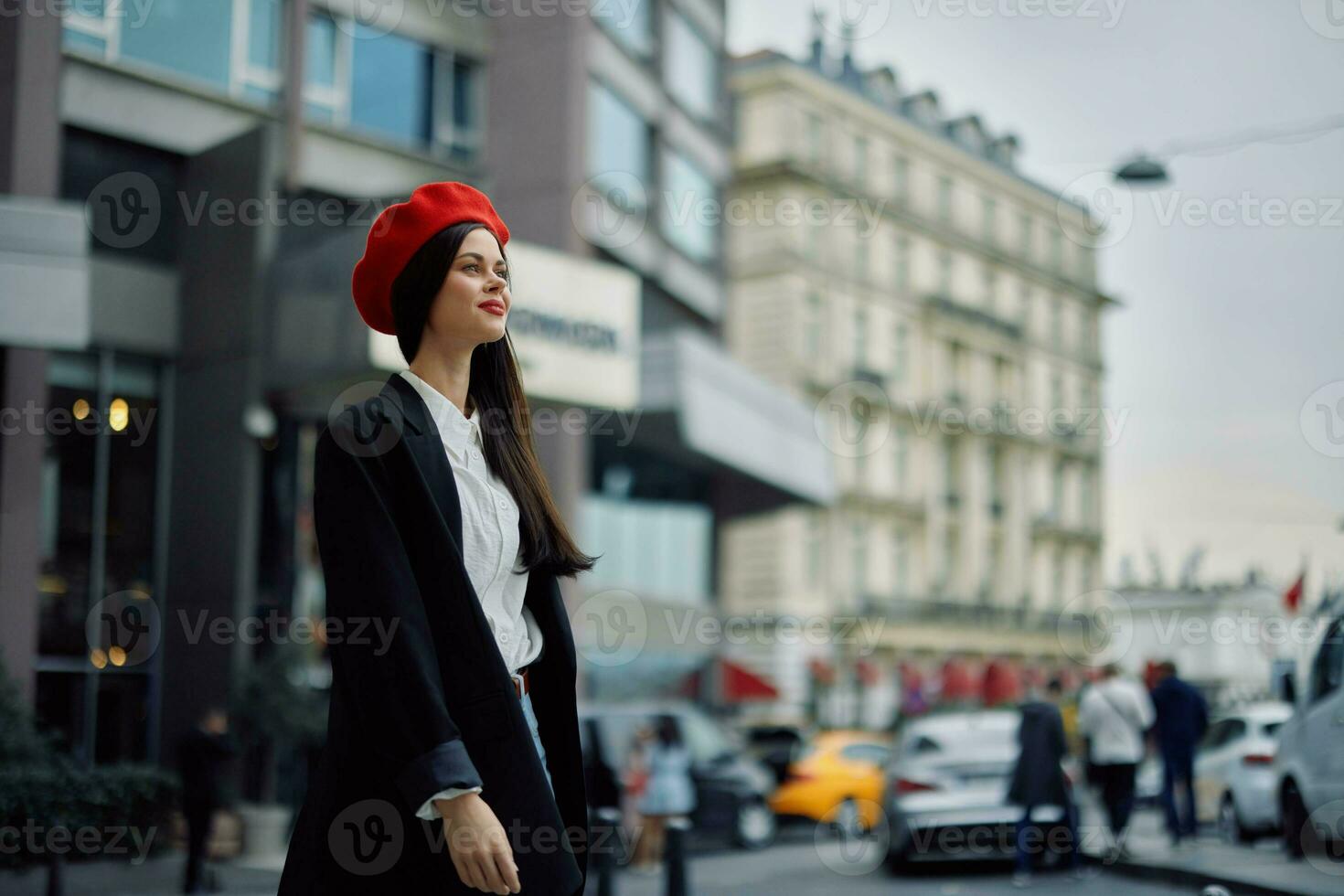 une sourire femme avec affaires les dents des promenades dans le ville contre le toile de fond de Bureau bâtiments, élégant à la mode vêtements et se maquiller, printemps marcher, Voyage. photo