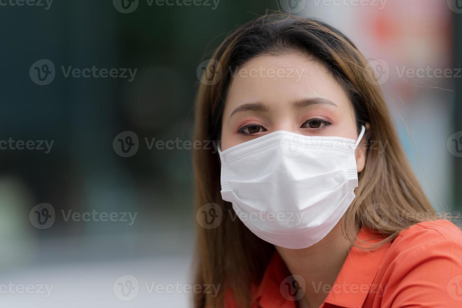 Portrait de jeune femme portant un masque protecteur assis dans un café photo