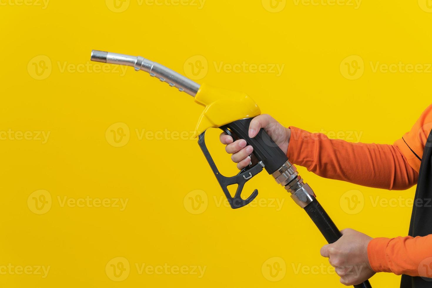 Femme tenir la buse de carburant sur fond jaune photo