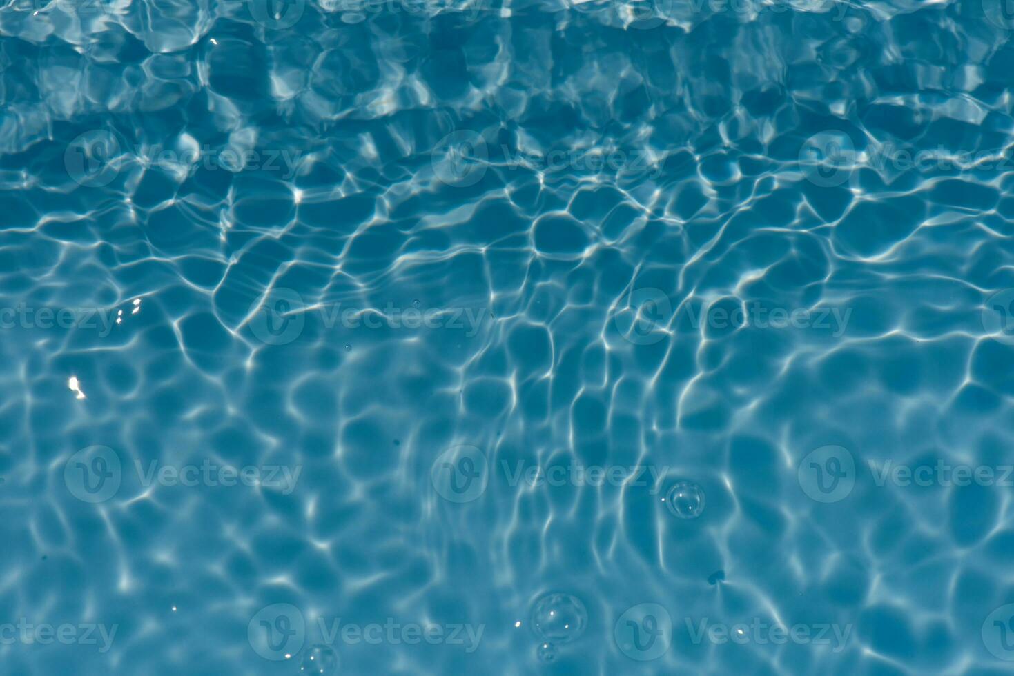 bleu l'eau avec ondulations sur le surface. défocalisation flou transparent bleu coloré clair calme l'eau surface texture avec éclaboussures et bulles. l'eau vagues avec brillant modèle texture Contexte. photo