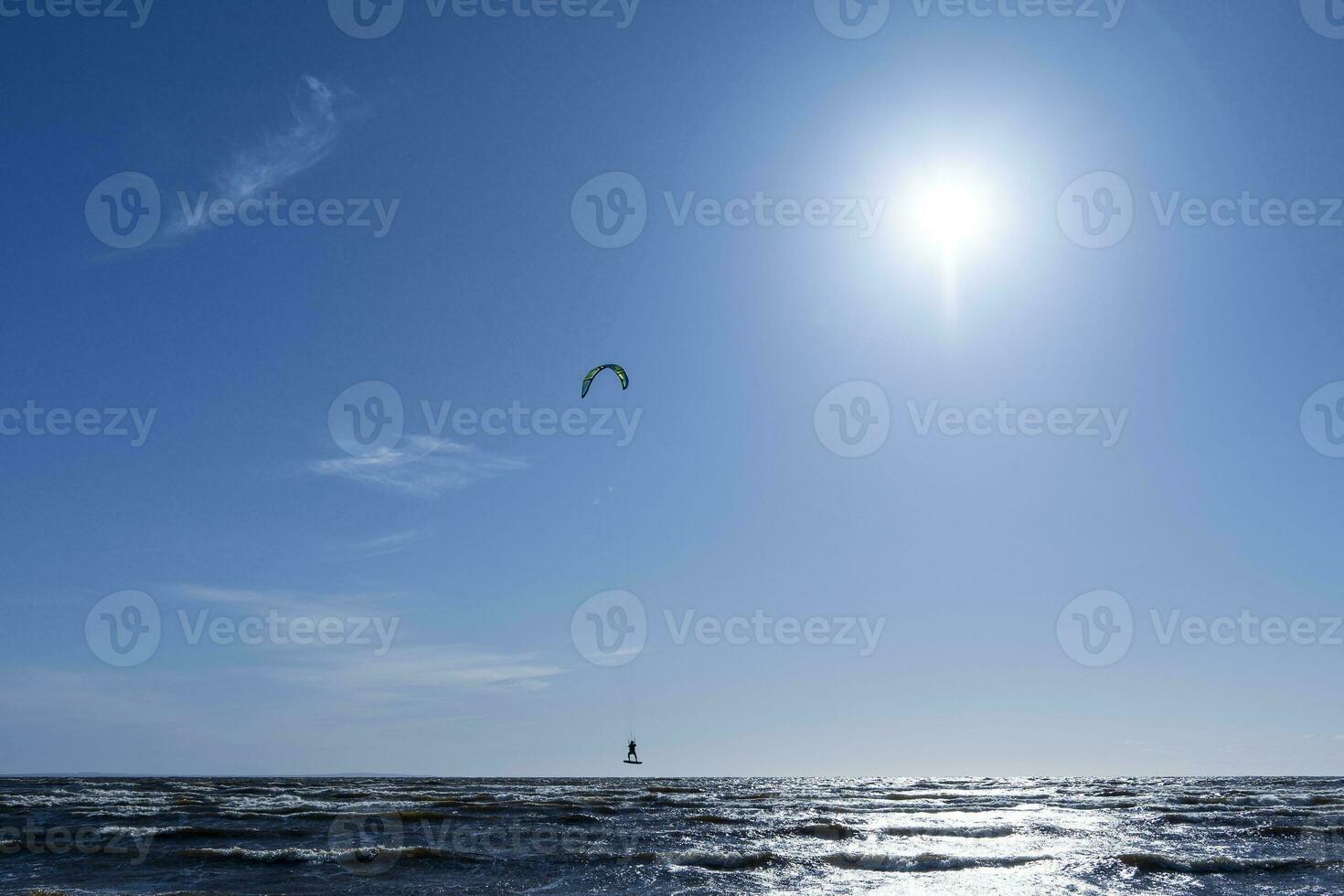 kite surf à mer tandis que performant des trucs. liberté, force, rêves. photo