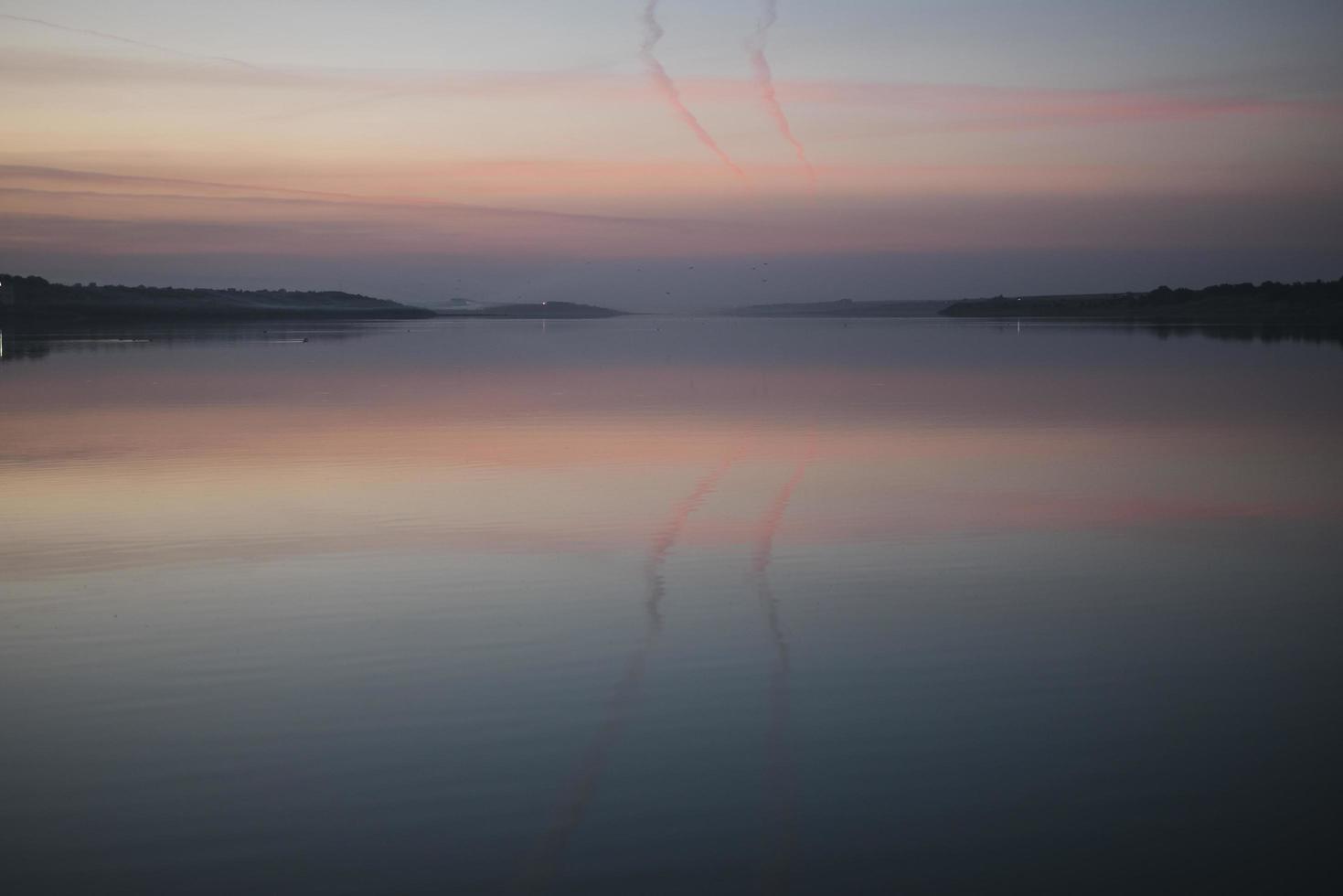 une brume sur l'eau au coucher du soleil au coucher du soleil sur le lac photo