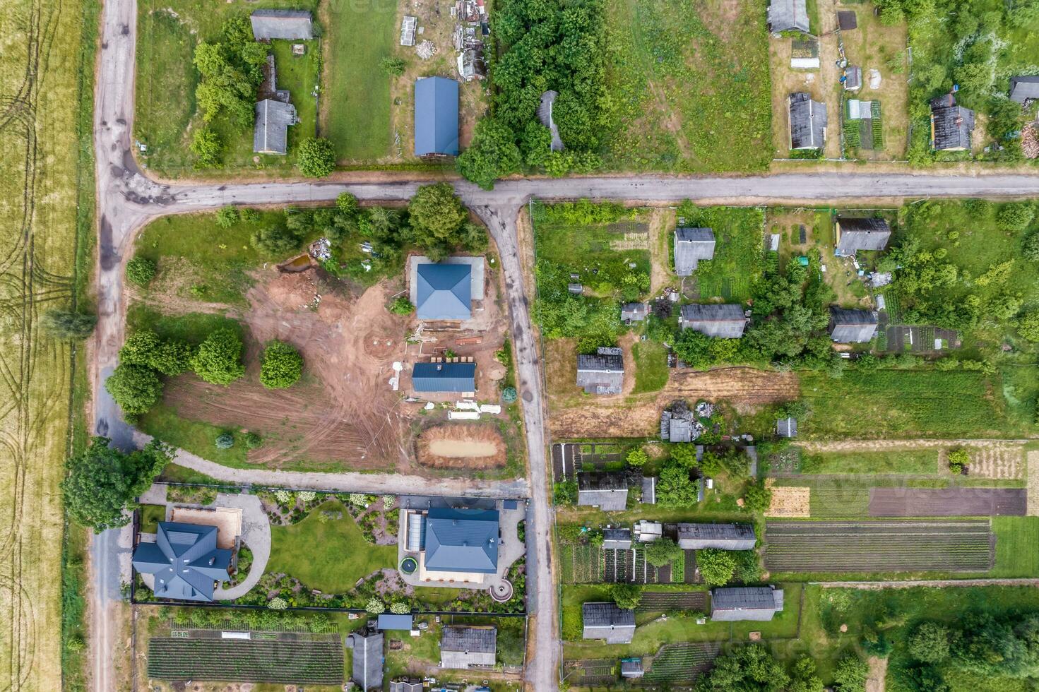 panoramique aérien vue de éco village avec en bois Maisons, gravier route, jardins et vergers photo