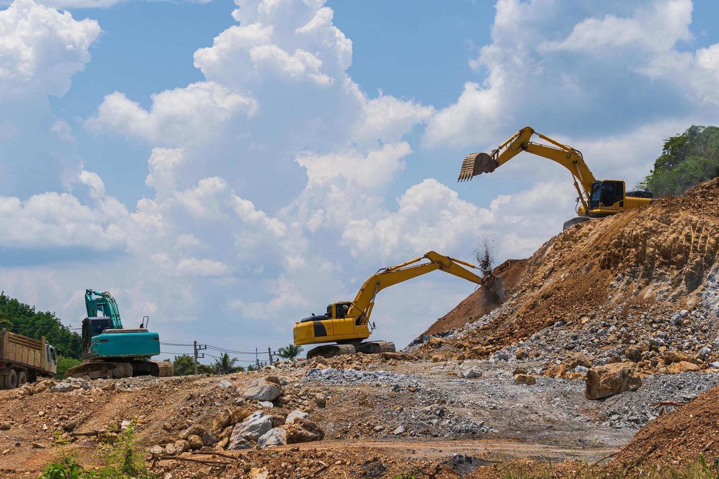 Excavatrice travaillant à l'extérieur sous le ciel bleu photo