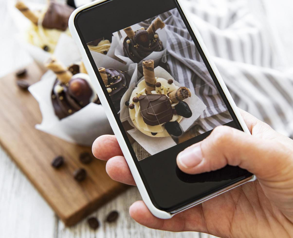 fille fait une photo de petits gâteaux sur un smartphone