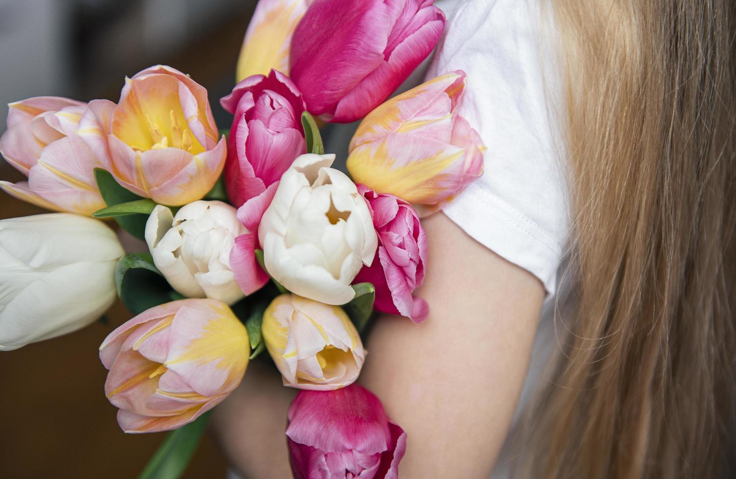 tulipes de printemps entre les mains d'une petite fille. photo