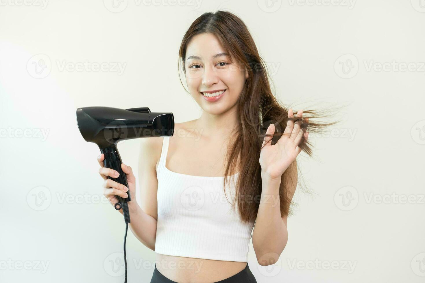 cheveux séchoir, magnifique content, asiatique Jeune femme, fille main dans en utilisant, en portant sèche-cheveux à sec, soufflant blond longue tout droit après douche à maison. coiffure, cheveux traitement isolé sur Contexte. photo